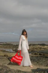 Bolso tipo tote tejido a crochet, con hilo 100% algodón, a rayas horizontales color crema y lila, con volados en los bordes y manijas reforzadas.