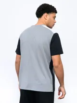 Remera deportiva Umbro de corte clásico, color gris con mangas cortas blancas y logo de la marca en el pecho.