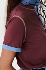 Remera blanca de manga corta con cuello redondo y detalle de costuras en contraste en cuello y mangas.