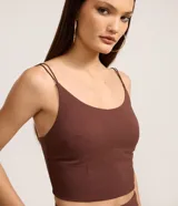 Top corto de color marrón oscuro, con escote en U y tirantes finos ajustables. Presenta un corte tipo corsé en la parte inferior del busto.