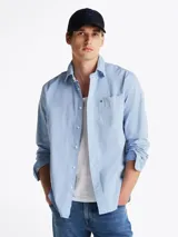 Camisa celeste de corte amplio confeccionada en sarga de puro algodón teñido en prenda, con cuello abotonado, bolsillo de parche en el pecho, puños redondeados con botón y logo de Tommy Hilfiger bordado en el bolsillo del pecho.