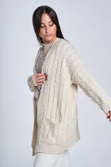 Saco tejido color crema con diseño de ochos y bolsillos frontales.