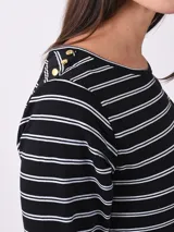 Remera marrón de manga larga con cuello redondo y detalle de botones dorados en los hombros.