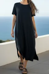 Vestido negro de viscosa y elastano, corte recto, largo midi y mangas cortas.