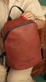 Mochila marrón de símil cuero con cierre principal y bolsillo interno con cierre. Tiene asa de mano, correas regulables y bolsillo oculto en la espalda.