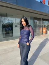 Top azul con mangas largas de tul y cuerpo de cuero sintético con drapeado horizontal en el busto.