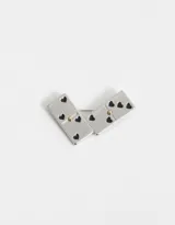 Broche prendedor con forma de dos fichas de dominó unidas, esmaltadas en color plateado con corazones negros y detalles dorados.