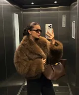 Chaqueta corta de pelo sintético color marrón, con cuello amplio y mangas abullonadas.