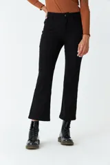 Pantalón de pana negro, de corte recto y tiro medio, con bolsillos y presillas para cinturón.