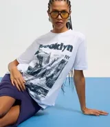 Remera blanca de algodón con estampado de fotos y texto alusivo a Brooklyn, Nueva York.