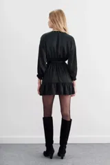 Vestido corto color violeta, de escote cruzado con volados, mangas largas abullonadas y cintura elastizada. Confeccionado en jacquard con corazones.