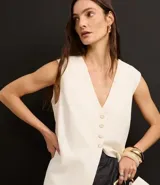 Chaleco largo color crema, con botones delanteros y lazo en la espalda.