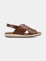 Sandalia marrón con textura croco, tiras cruzadas y ajuste elástico en el talón.