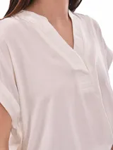 Blusa color gris con cuello en V y mangas cortas.