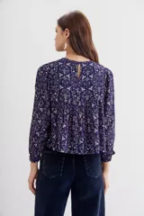 Blusa amplia de mangas largas y cuello redondo, estampada con detalles de lurex, punto smock en el frente y frunces en la espalda.