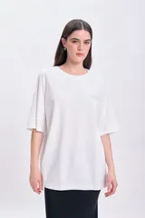 Remera blanca de corte oversize con estampado en la espalda que incluye la frase 'Amalfi Coast', un diseño a cuadros rojos y dibujos de sardinas con rodajas de limón.