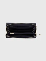Billetera grande Tommy Hilfiger City, color negro, con cierre de solapa y cremallera. Incluye múltiples ranuras interiores para tarjetas y logo TH dorado en relieve.