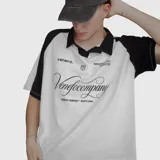 Polo oversize blanco y negro con cuello clásico, mangas cortas y estampado con el logo de la marca en el frente.