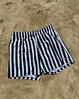 Short de baño blanco con rayas verticales verdes y cordón de ajuste negro.