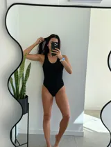 Traje de baño entero negro con breteles anchos y escote redondo.