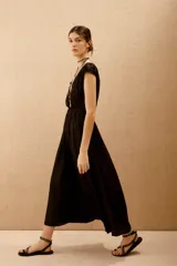 Vestido largo negro con escote en V y mangas cortas caídas.