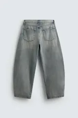 Pantalón de jean celeste con efecto lavado, corte amplio tipo balloon fit, tiro medio, cinco bolsillos y cierre frontal con cremallera y botón.