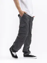 Pantalón de trekking convertible color verde militar, con piernas removibles mediante cierre a la altura de la rodilla, transformándolo en bermuda. Presenta múltiples bolsillos cargo con tapa y cierre, y cintura con pasadores para cinturón.