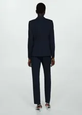 Blazer azul marino con cuello de pico y solapa, hombros estructurados, diseño entallado y dos bolsillos de ribete en la parte delantera.