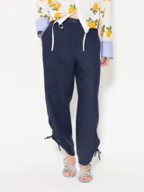 Pantalón largo de lino color blanco, de corte amplio y tiro alto. Presenta recortes en delantero y espalda, bolsillos escondidos al frente y bolsillos ojal en la parte posterior. Lleva jareta con lazo para ajustar y bordado marcario JCH en el delantero.