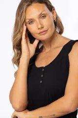 Musculosa celeste de algodón y poliéster, con breteles anchos con volados y tres botones en el escote.