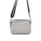 Cartera bandolera Korium color gris claro con diseño geométrico acolchado. Tiene correa de hombro ajustable en color negro y cierre superior con cremallera.