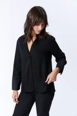 Camisa negra de manga larga con cuello clásico y cierre frontal con botones.