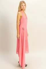 Vestido midi de fiesta color rosa coral, con escote halter, espalda descubierta y falda asimétrica con detalle de flor en la cintura.