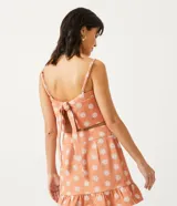 Blusa musculosa cropped color salmón con estampado de mandalas blancas, tirantes finos ajustables y lazo en la espalda.