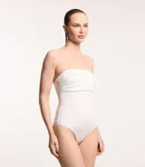 Body blanco de jersey, sin breteles, con escote recto y busto doble fruncido.