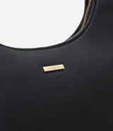 Cartera tipo baguette color beige, confeccionada en PU con acabado liso. Cuenta con cierre de cremallera y metales en tono dorado claro. El asa es ajustable y tiene un espacio interno ideal para el uso diario.