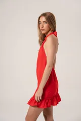 Vestido corto rojo de tela polina, con cuello halter, sin mangas y volado en el ruedo.