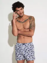 Bóxer de algodón blanco con estampado de flores pequeñas color celeste, con cintura elástica y logo de la marca en el centro.