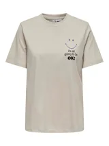 Remera color crema de algodón orgánico con cuello redondo y mangas cortas. Estampado frontal con una carita sonriente azul y la frase "it's all going to be OK!" en negro.