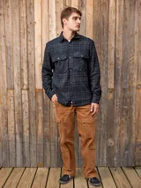 Sobrecamisa de manga larga a cuadros grises y negros, con cuello camisero, cierre frontal con botones, bolsillos de parche en el pecho y corte regular.