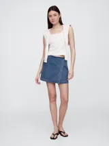 Short pollera de jean color celeste claro, con corte asimétrico y detalle de costuras a la vista.