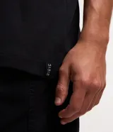 Musculosa blanca de algodón con cuello redondo y corte clásico.
