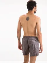 Short de baño gris con estampado de líneas verticales negras.