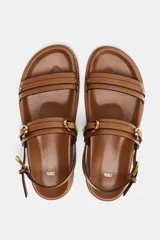Sandalias planas color marrón con doble tira delantera con detalle de hebilla. Cierre mediante hebilla en la pulsera al tobillo.