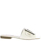 Zueco tipo mule (chinela cerrada) de cuero blanco, con tira ancha sobre el empeine adornada con una hebilla rectangular grande de color blanco y negro.