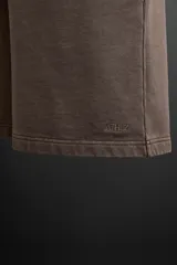 Bermuda jogger negra confeccionada en tejido de algodón con interior de rizo, cintura elástica ajustable con cordón y bolsillos laterales.