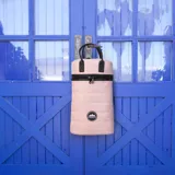 Matera estilo mochila color negro, confeccionada en nylon combinado con símil cuero. Cuenta con tapa con cierre metálico, bolsillo interno, asas y correa extensible.