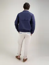 Cazadora tipo bomber color beige, con cierre frontal y bolsillos de solapa.