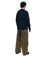 Pantalón unisex de denim 100% algodón con acabado marmolado color bronce. De tiro medio y calce wide/relajado, con pierna muy amplia y caída larga. Cintura con elásticos laterales, costuras curvas y bolsillos delanteros y traseros con bocas redondeadas.