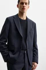 Blazer slim fit azul marino confeccionada en tejido con 17% de lana. Cuello con solapas de muesca, manga larga acabada en puño con detalle de botones, bolsillo de vivo en pecho y de solapa en cadera, detalle bolsillo interior, bajo con aberturas en espalda y cierre frontal con botones.